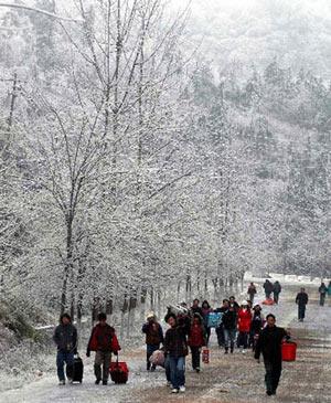 Migrant workers walk on their way home from Kaili, a city in southwest China's Guizhou Province, Jan. 23, 2008. The 40-day Spring Festival travel peak across the country started on Jan. 23. Passengers in Guizhou walk home for the Spring Festival celebration because roads were blocked owing to the heavy snow. (Xinhua Photo)