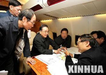 Chinese Premier Wen jiabao (3rd L) listens to an unidentified official on boarding the special plane flying from Beijing to central China's Hunan Province on Jan. 28, 2008. Wen went to Hunan Monday for an inspection tour of this snow and ice stricken province. (Xinhua Photo)