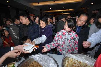 Passengers stranded in Beijng-Zhuhai expressway, who have been evacuated to Xiangtan City, receive meals in a hotel where they are settled, in Xiangtan City, Hunan Province, central China, Jan. 29, 2008. Due to the closure of the expressway linking Beijing with Zhuhai in south China's Guangdong Province a week ago, more than 20,000 vehicles with 60,000 people were stranded near Hunan's Xiangtan City. Hunan Province carried out urgent rescue and evacuation work on Tuesday. Up to 12 a.m. on Jan. 29, the stranded vehicles were decreased to 6,400 with about 20,000 people on board. (Xinhua Photo)