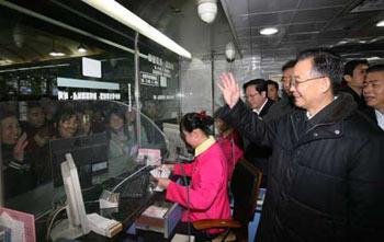 Chinese Premier Wen Jiabao (front R) waves to passengers when he visits the ticket office at a long-distance coach station of Guangzhou, capital of south China's Guangdong Province, Jan. 30, 2008.(Xinhua Photo)