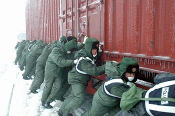 Soldiers push a container truck stranded on a snow-plagued stretch of the Beijing-Zhuhai Expressway in Shaoguan, South China's Guangdong Province, Jan. 31, 2008.(Xinhua Photo)