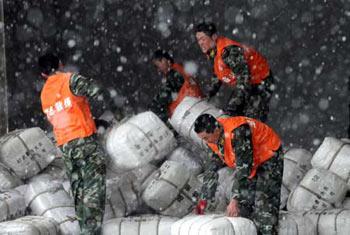 Soldiers of the armed police force carry disaster-relief resources in Wuhan, capital of central China's Hubei Province, Feb. 1, 2008. Some 120,000 clothes and quilts were sent to people suffering from severe snowstorm and frost in Hubei province on Friday. (Xinhua Photo)