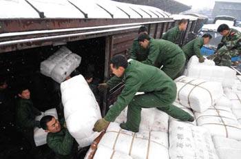 Soldiers of the armed police force carry disaster-relief resources out of a train in Wuhan, capital of central China's Hubei province, Feb. 1, 2008. Some 120,000 clothes and quilts were sent to people suffering from severe snowstorm and frost in Hubei province on Friday. (Xinhua Photo)