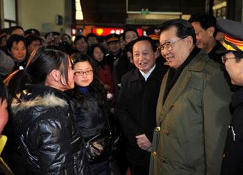 Li Changchun (front R2), member of the Standing Committee of the Political Bureau of the Communist Party of China (CPC) Central Committee, talks with passengers at the Hankou Railway Station in Wuhan, capital of central China's Hubei Province, Jan. 30, 2008. Entrusted by CPC Central Committee General Secretary Hu Jintao, Li Changchun has paid a visit to Hubei recently to meet the people suffering from snowstorm and inspect disaster relief work on behalf of the CPC Central Committee and the State Council.(Xinhua Photo)