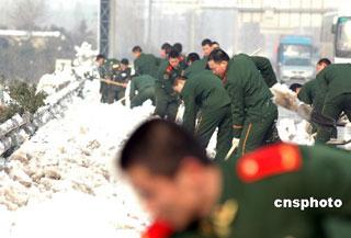 Armed-police soldiers clean the snow-covered road.
