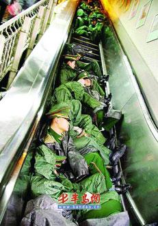Exhausted armed-police soldiers take a nap on the elevator at Guangzhou railway station.