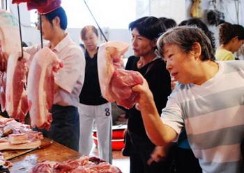 Consumers shop for pork at a market in Yunyang County, Southwest China's Chongqing Municipality in this September 14, 2007 photo. [Asianewsphoto]