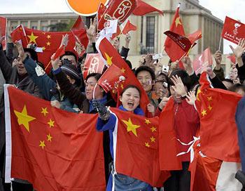 Spectators cheer and wave Chinese national flags as they watch the Olympic torch relay in Paris, capital of France，on April 7, 2008. Paris is the fifth stop of the 2008 Beijing Olympic Games torch relay outside the Chinese mainland. (Xinhua Photo)