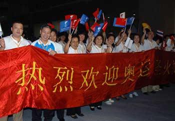 Staff of Chinese embassy to Thailand greet the Olympic flame upon its arrival at an airport in Bangkok, capital of Thailand, April 18, 2008. Bangkok is the 12th leg of the 2008 Beijing Olympic Games torch relay global tour outside the Chinese mainland.(Xinhua/Gong Lei) 