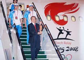 Jiang Xiaoyu, executive vice president of the Beijing Organizing Committee for the 2008 Olympic Games (BOCOG), walks out of the cabin with the lantern which holds the Olympic flame at the airport in Kuala Lumpur, capital of Malaysia, April 20, 2008. The flame of the 2008 Beijing Olympic Games on early Sunday arrived in the Malaysia capital of Kuala Lumpur, the 13th leg of its global torch relay. (Xinhua Photo)