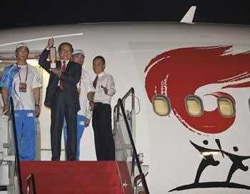 Jiang Xiaoyu (m), executive vice president of the Beijing Organizing Committee for the 2008 Olympic Games (BOCOG), walks out of the cabin with the lantern which holds the Olympic flame at the airport in Jakarta, the capital of Indonesia, April 22, 2008. The flame of the 2008 Beijing Olympic Games early Tuesday arrived in the Indonesia capital of Jakarta, the 14th leg of its global torch relay.(Xinhua Photo)