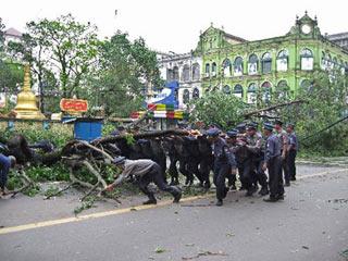 Policemen remove a uprooted tree from a street in Yangon. (Xinhua/AFP Photo)