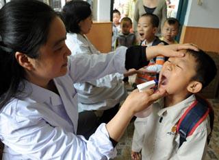 Children are examined in a kindergarten in Zhengzhou, capital of central China's Henan Province, May 5, 2008. In order to ensure children's health and prevent diseases transmitted by hand, foot or mouth, lots of kindergartens in Zhengzhou started to practice morning examination after the May Day Holidays to promote health habits as washing hands, basking and eating well-cooked food. (Xinhua Photo)