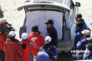 Zhang Zhijian, spokesman for the Chinese Mountaineering Team, is surrounded by reporters inquiring about the route of the Olympic torch relay up to the world's highest peak after they noticed the spokesman sneaking out of media center on Wednesday, May 7, 2008. [Photo: cnsphoto]