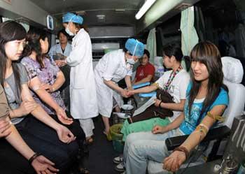 Blood donators wait for blood extraction in the compartment of a bloodmobile, at Nangchong, southwest China's Sichuan Province, May 13, 2008. The public of Nanchong City actively donate blood to help victims of the quake that rocked the Sichuan Province with the epicenter at Wenchuan County on Monday. There is a large demand for blood in quake-hit areas and feedback from the quake-stricken areas shows blood and plasma products are urgently needed.(Xinhua Photo)