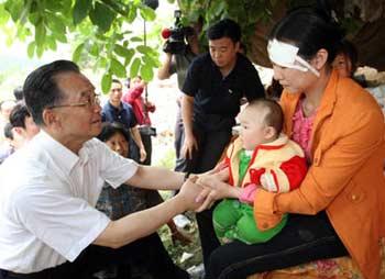 Chinese Premier Wen Jiabao (L) comforts local people in Muyu Township, Qingchuan County, southwest China's Sichuan Province May 15, 2008. Qingchuan County is one of the worst-hit areas in Sichuan Province. Premier Wen is here to oversee rescue work and visit survivors.(Xinhua/Yao Dawei)