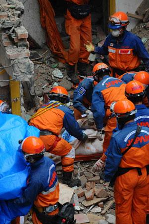 Members of the Japanese rescue team package the body of a victim at Qiaozhuang Town of Qingchuan County in the quake-stricken southwest China's Sichuan Province, May 17, 2008. Japanese earthquake rescuers found two corpses in a collapsed six-floor building in Qiaozhuang at 7:25 am after 16 hours rescue operation. (Xinhua/Li Tao)