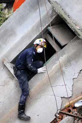 A member of a rescue team from Singapore searches for survivors in the quake-hit Hongbai Town of Shifang City in southwest China's Sichuan Province, May 17, 2008. The team of 55 members from Singapore started their rescue mission in the serious devastated Hongbai Town on Saturday.(Xinhua/Jiang Fan)