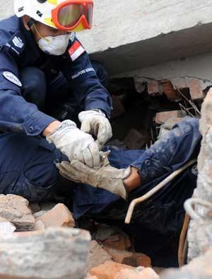 Members of a rescue team from Singapore search for survivors in the quake-hit Hongbai Town of Shifang City in southwest China's Sichuan Province, May 17, 2008. The team of 55 members from Singapore started their rescue mission in the serious devastated Hongbai Town on Saturday.(Xinhua/Jiang Fan)