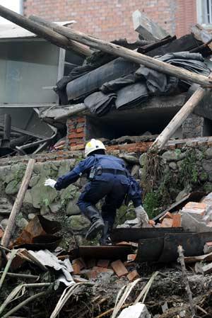 A member of a rescue team from Singapore searches for survivors in the quake-hit Hongbai Town of Shifang City in southwest China's Sichuan Province, May 17, 2008. The team of 55 members from Singapore started their rescue mission in the serious devastated Hongbai Town on Saturday.(Xinhua/Jiang Fan)