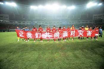 The Chengdu Blades football team, from the capital of the earthquake ravaged Sichuan Province, unfold a red scroll proclaiming "Let's Face the Disaster Together," in Changsha on Saturday, May 17, 2008.(Photo: CRIENGLISH.com/hnol.net)
