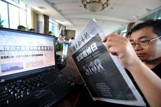 A citizen looks at a newspaper with a bold-face front page in Wuhan, capital of central China's Hubei Province, May 19, 2008.  (Xinhua Photo)