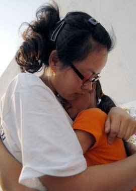 A psychologist hugs a girl who experienced last Monday's earthquake in southwest China's Sichuan Province May 19, in Mianyang, Sichuan.(Xinhua Photo)
