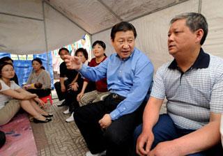 Chinese Vice President Xi Jinping (2nd R) talks with quake-affected people relocated at Jialing Square of Lueyang County of northwest China's Shaanxi Province, in which some counties were seriously affected by the deadly quake in neighboring Sichuan Province last week, on May 20, 2008.(Xinhua Photo)