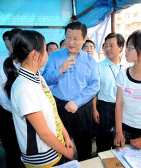 Chinese Vice President Xi Jinping (C) talks with students at a makeshift classroom during his inspection in Lueyang County of northwest China's Shaanxi Province, in which some counties were seriously affected by the deadly quake in neighboring Sichuan Province last week, on May 20, 2008.(Xinhua Photo)