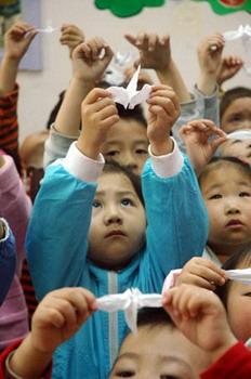 Children in a kindergarten in Mudanjiang City, Heilongjiang Province hold paper cranes to mourn the Wenchuan earthquake victims May 20, 2008.  (Xinhua Photo)