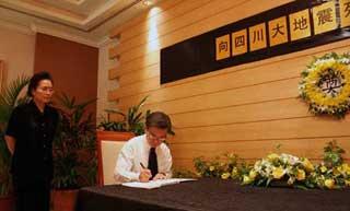 Singapore's Deputy Prime Minister and Minister for Home Affairs Wang Kan Seng (R) leaves words on the condolence book at the Chinese embassy to Singapore, May 21, 2008. Wang Kan Seng visited the Chinese embassy on Wednesday to mourn the victims of the deadly earthquake that hit southwest China's Sichuan province last week.(Xinhua Photo)