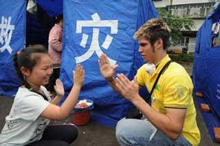 An American volunteer plays with a girl at a disaster-relief tent in the quake-hit city of Shifang, southwest China's Sichuan Province, May 21, 2008. The American volunteers have come to earthquake-stricken areas in the province to help rescue the victims there.(Xinhua Photo)