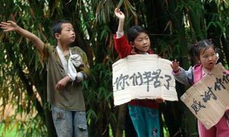 Children holding placards wave to the passing-by rescuers to express their gratitude beside the road linking the quake-devastated Qingchuan and Guangyuan of southwest China's Sichuan Province, May 21, 2008. (Xinhua Photo)