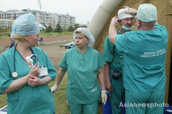 Members of Russia medical team prepare for an operation in outside the operationg room in the quake-hit Pengzhou City, Sichuan Province May 21, 2008. [Asianewsphoto]