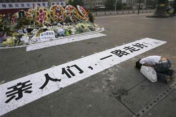 A girl mourns her relatives who died during the earthquake, at a square in Chengdu, Sichuan province May 19, 2008. The banner on the ground reads in Chinese, "Dearests, have a smooth journey". [Agencies]