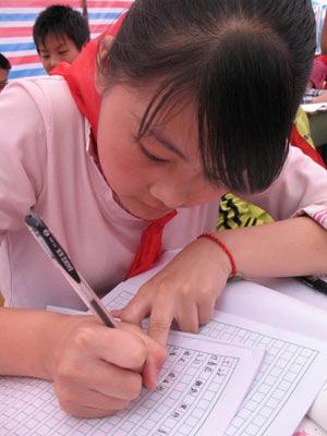 A girl signs in at a tent school set up at a temporary resettlement in Nanhe Sports Center of Mianyang City, southwest China's Sichuan Province, May 22, 2008. The love tent school was opened for some 700 students from quake-hit areas on Thursday.(Xinhua Photo)