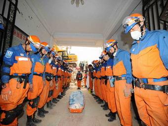 Japanese rescue members pay respects to the bodys of the female victim Song Aimei and her 70-day-old baby after 16 hours of searching through the debris in Qingchuan County, Sichuan Province. [Xinhua]