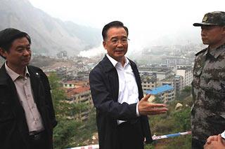 Chinese Premier Wen Jiabao (C) talks to local officials in Beichuan, southwest China's Sichuan Province, on May 22, 2008. Wen Jiabao made his second trip to the quake-battered zone on Thursday afternoon to oversee disaster relief work. (Xinhua/Yao Dawei)