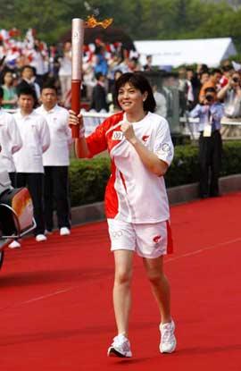 Torchbearer Zhuang Yong runs with the torch during the 2008 Beijing Olympic Games torch relay in Shanghai, east China, on May 23, 2008. (Xinhua Photo)