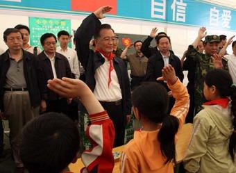 Chinese Premier Wen Jiabao (C) salutes with the students to pay tribute to the quake victims during his visit to the makeshift tent school at Jiuzhou Stadium in Mianyang City, southwest China's Sichuan Province, May 23, 2008. Wen Jiabao went to the temporary schoolhouse of Beichuan Middle School and the makeshift tent school established at Jiuzhou Stadium in Mianyang on Friday to visit teachers and students who survived the May 12 earthquake.(Xinhua Photo)