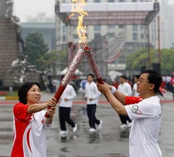 Sun Wen passed the torch to Chen Fei from the Shanghai Firefighting Bureau, one of four quake rescuers to carry the torch on Saturday. 