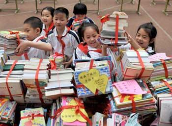 Students of the Kangleli Primary School of Xuanwu District, Beijing, donate books to their friends in the quake-devastated areas on May 26, 2008. Young Pioneers donate their pocket money and books to the quake survivors. So far, about 15 million RMB yuan and some relief materials donated by the young pioneers in Beijing have been sent to the disaster areas.(Xinhua Photo)