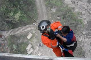 A rescue personnel of Nanhai No.1 Rescue Flying Team evacuates a tourist by helicopter from Longmenxia, near Mianyang, Sichuan province May 22, 2008. [Asianewsphoto]