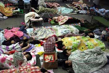 Residents sleep outside to avoid the aftershock likely to happen in Chengdu, capital of southwest China's Sichuan Province on the early morning of May 20, 2008. The provincial seismological bureau in Sichuan forecasted on Monday night that an aftershock between 6.0 to 7.0 magnitude was likely to rock Wenchuan County on Monday or Tuesday, and warned local governments and people to be prepared for emergencies. (Xinhua/Wang Jianmin)