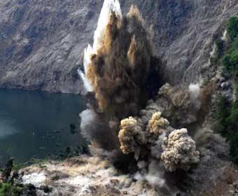 A demolition by explosives is carried out to the dam of the Shibangou quake lake in Qingchuan County, southwest China's Sichuan Province, June 4, 2008. A blasting task was carried out here at 18:24 pm Wednesday to widen the dam's sluice by 15 meters. A 12 million cubic meters quake lake, threatening the safety of thousands of people downstream, has been formed here after landslides triggered by the powerful May 12th earthquake striking southwest China's Sichuan Province. Under the continuous influences of aftershocks, rainfalls and other uncertain factors, chances for the quake lake to burst were growing higher.(Xinhua Photo)