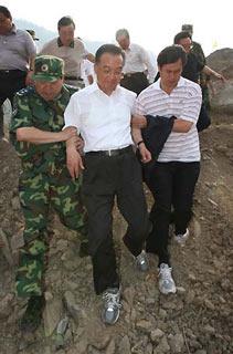 Chinese Premier Wen Jiabao (front C) is helped as he inspects the drainage of the Tangjiashan quake lake in southwest China's Sichuan Province on June 5, 2008. (Xinhua/Liu Weibing)