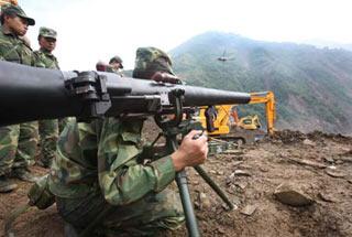 An engineering soldier prepares to fire a missile to blast boulders in a man-made sluice channel in Tangjiashan, quake-hit southwest China's Sichuan Province, June 8, 2008. A total of 4 missiles were fired on Sunday to clear boulders in the sluice channel, which speeded up the drainage of the dangerous Tangjiashan quake lake that began on Saturday morning.(Xinhua Photo)