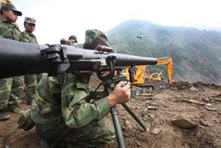 An engineering soldier prepares to fire a missile to blast boulders in a man-made sluice channel in Tangjiashan, quake-hit southwest China's Sichuan Province, June 8, 2008. A total of 4 missiles were fired on Sunday to clear boulders in the sluice channel, which speeded up the drainage of the dangerous Tangjiashan quake lake that began on Saturday morning.(Xinhua Photo)