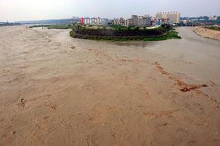 The drainage water of Tangjiashan quake-formed lake passes Mianyang City, southwest China's Sichuan Province, June 10, 2008. The crest of the flood from Tangjiashan quake-formed lake passed safely by downstream Mianyang City on Tuesday afternoon. (Xinhua Photo)