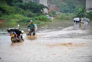 A man ride a motorcycle in the flooded street in Changzhou Town, Wuzhou City, southwest China's Guangxi Zhuang Autonomous Region, June 15, 2008.(Xinhua Photo)